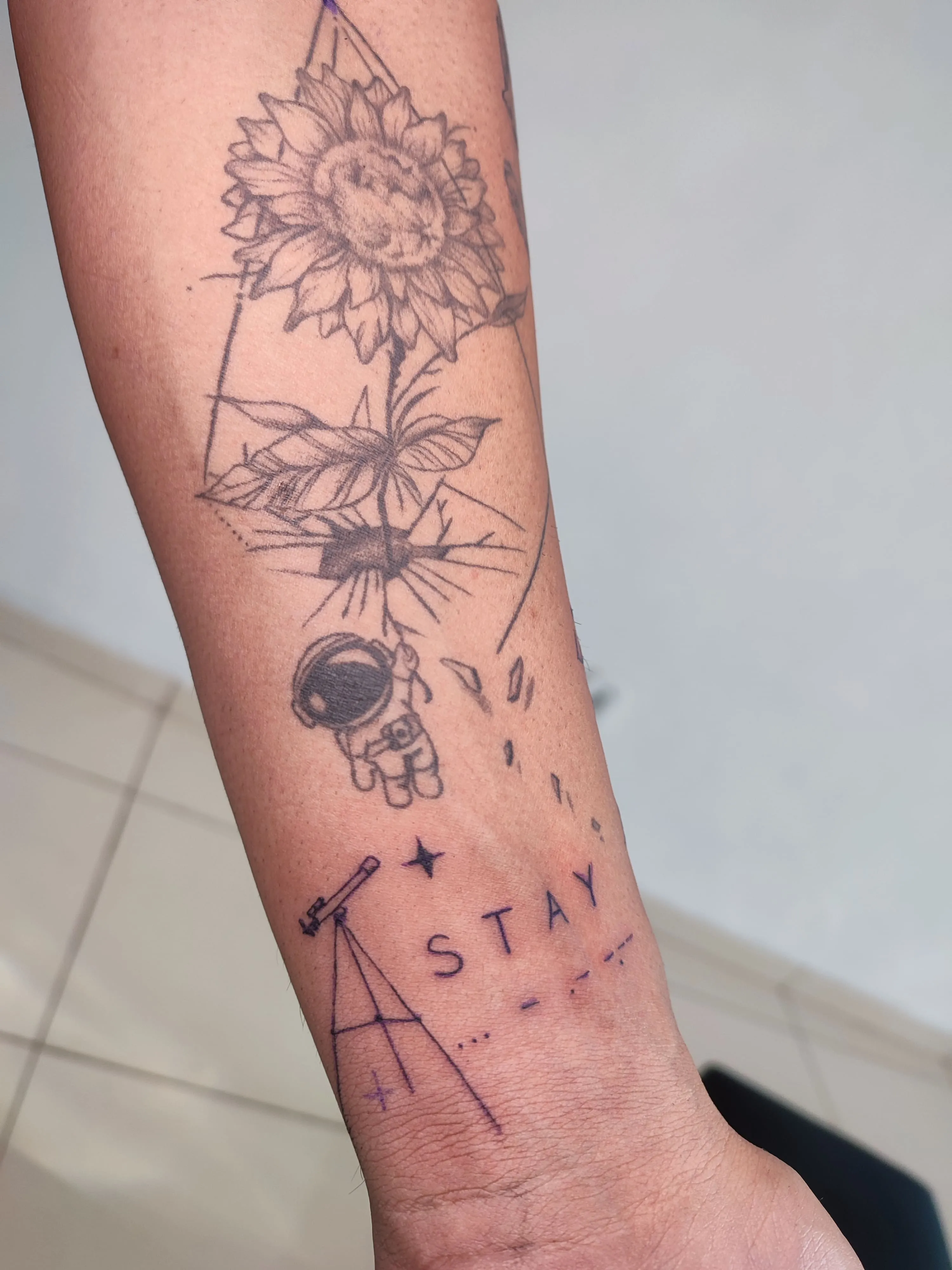 Tatuagem de couma girasol carregando um austronalta como se fosse uma balao