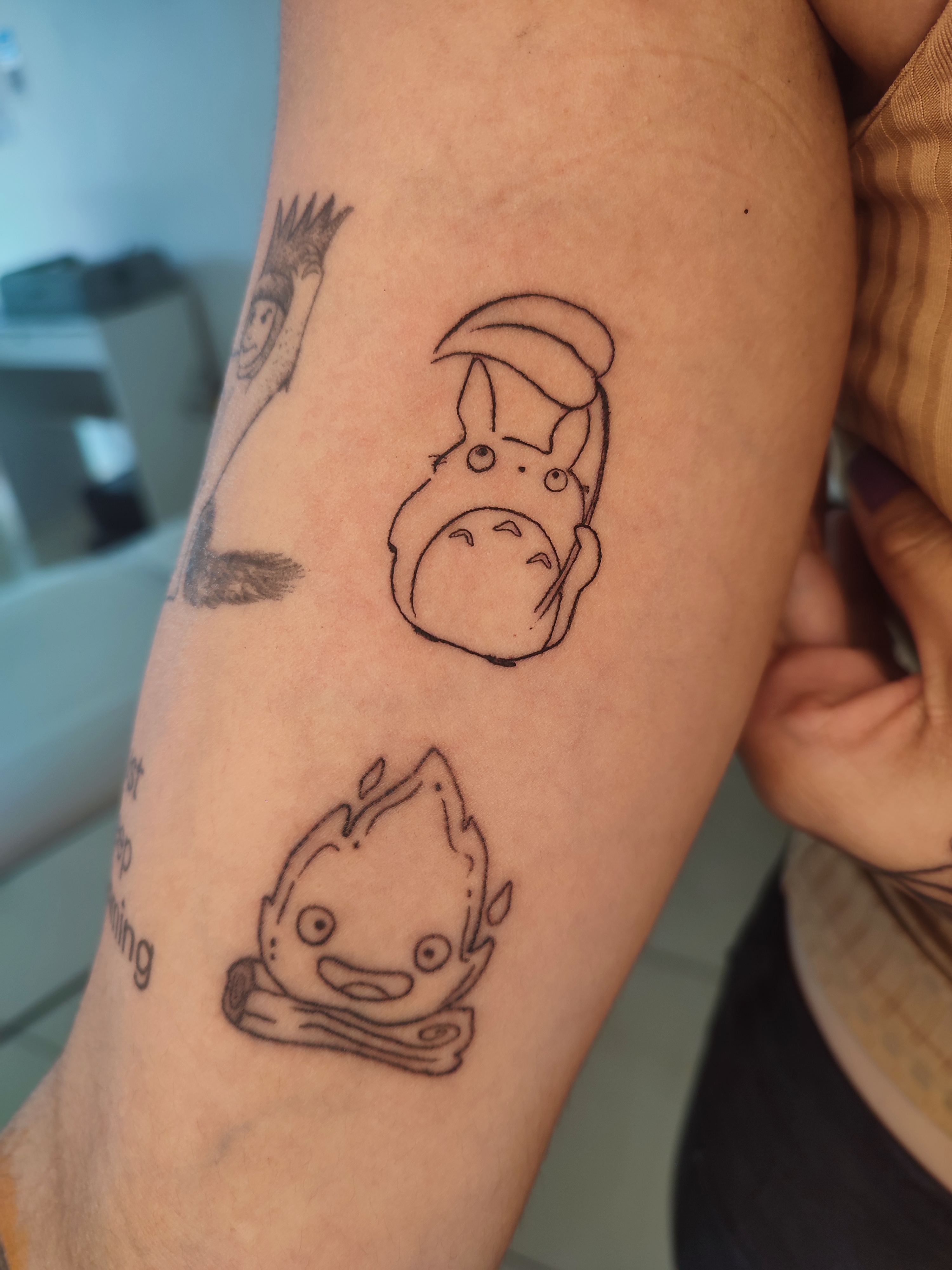 Tatuagem minimalista de um pokemon e um fogo 