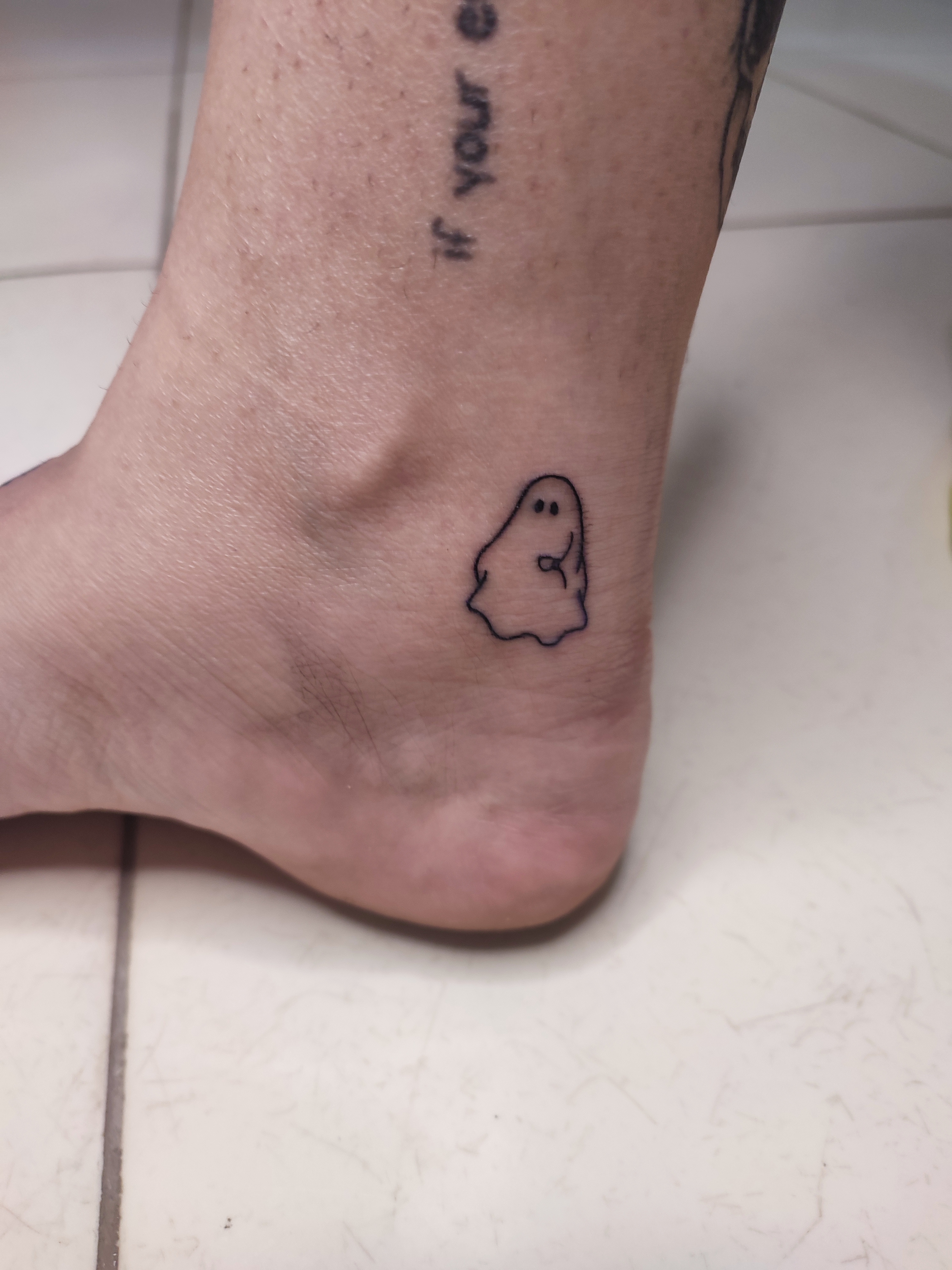 Tatuagem minimalista de um fantasminha fofinho