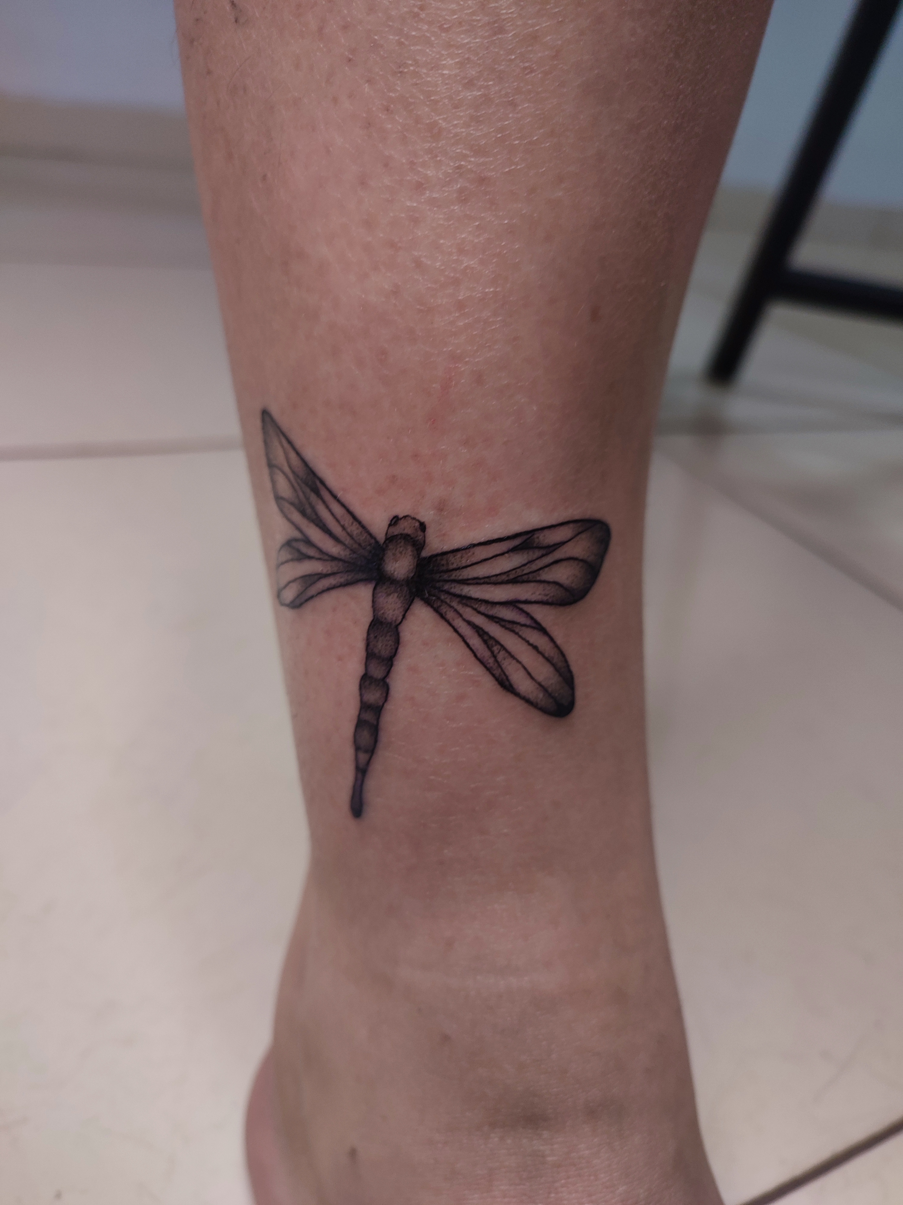 Tatuagem minimalista de uma Libélula