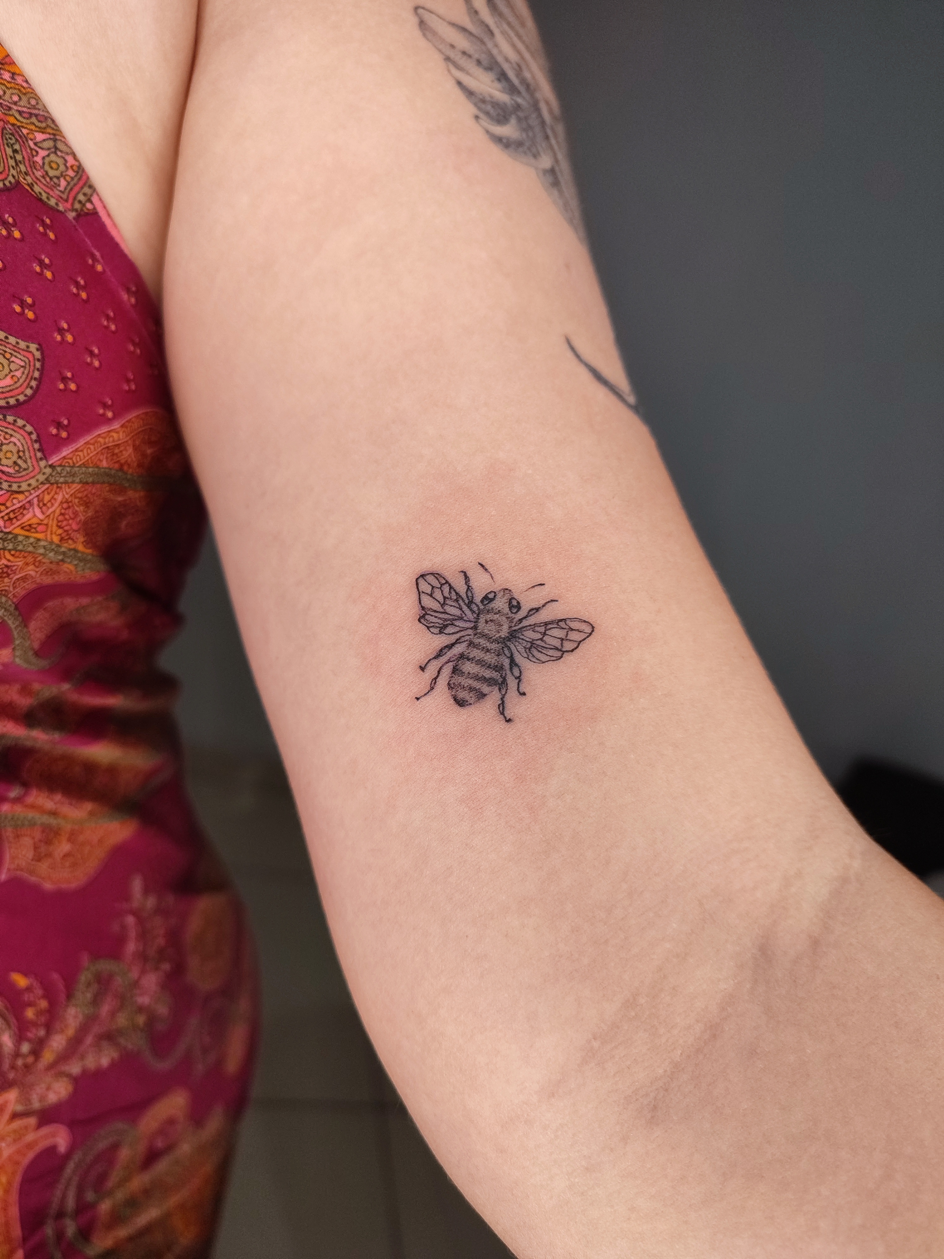 Tatuagem minimalista de uma abelha bem detalhada