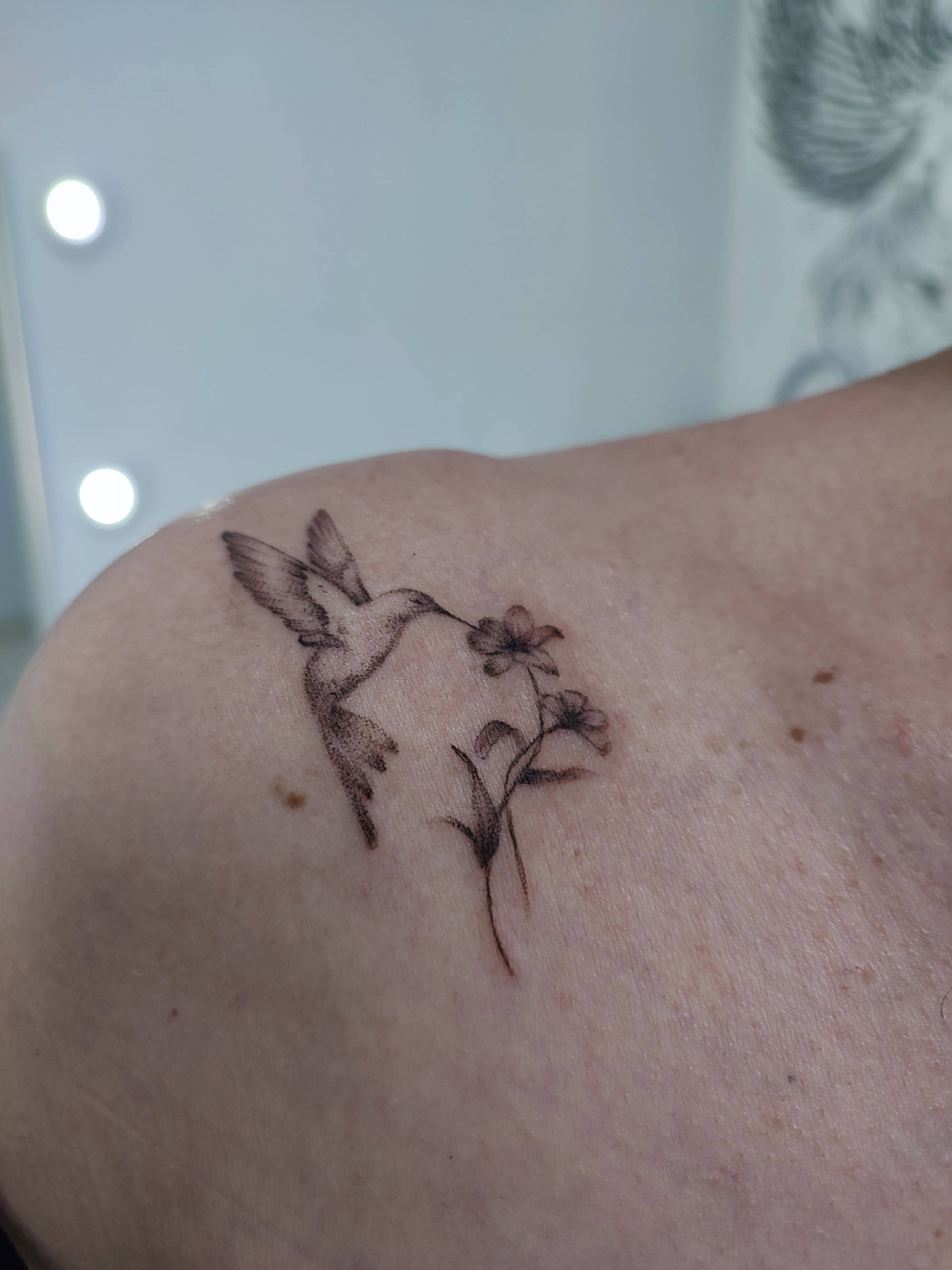 Tatuagem minimalista de um beija flor