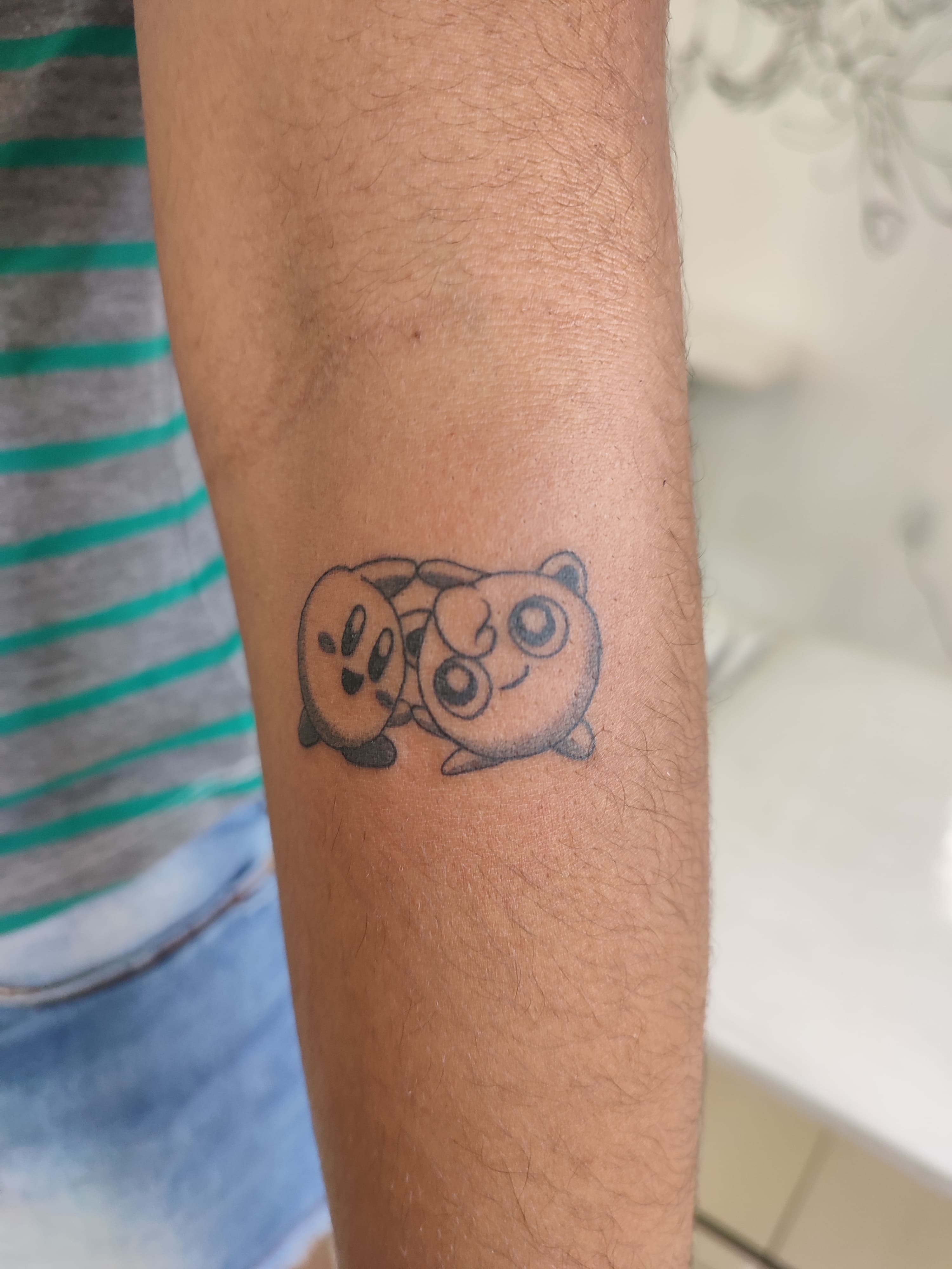 Tatuagem minimalista pokemons fazendo fusão